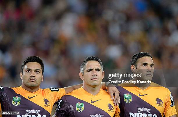 Alex Glenn, Corey Parker and Justin Hodges of the Broncos embrace for the playing of the last post for ANZAC day before the round 8 NRL match between...