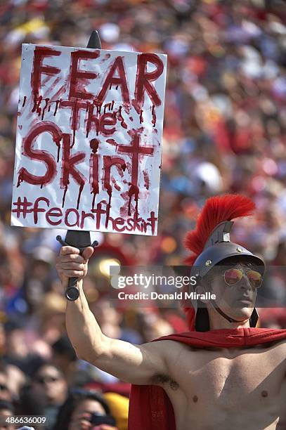 View of fan in Trojan helmet with sign reading FEAR THE SKIRT during USC spring game between White team vs Cardinal team at Los Angeles Memorial...