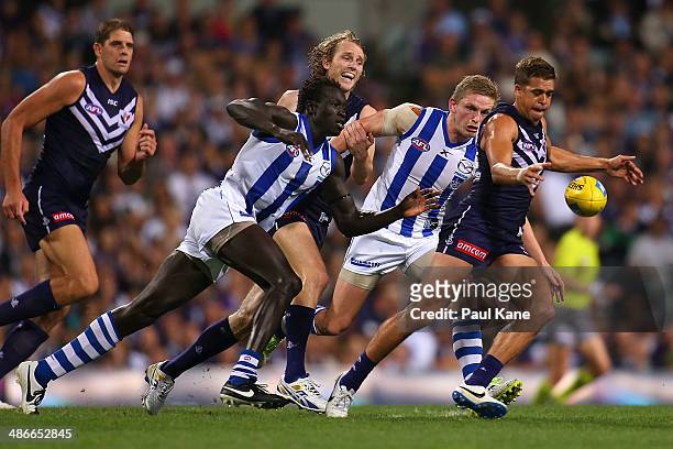 Majak Daw of the Kangaroos looks to tackle Stephen Hill of the Dockers during the round six AFL match between the Fremantle Dockers and the North...