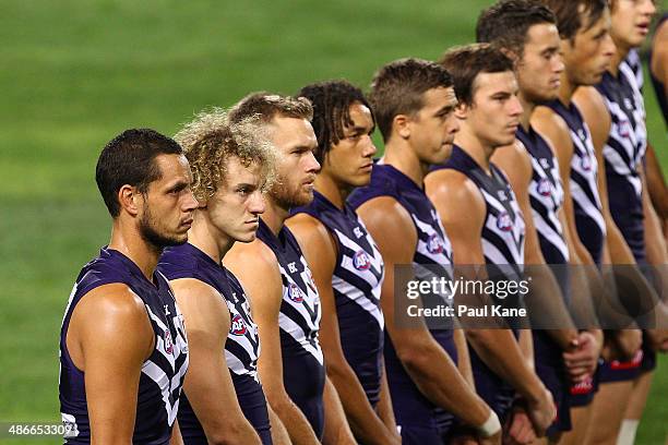 Dockers players line up for a minutes silence in tribute to Anzac Day during the round six AFL match between the Fremantle Dockers and the North...