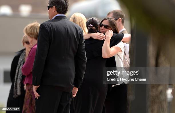 People comfort each other in front of Most Precious Blood Catholic Church. Kristine Kirk, allegedly killed by her husband while she called 911, is...