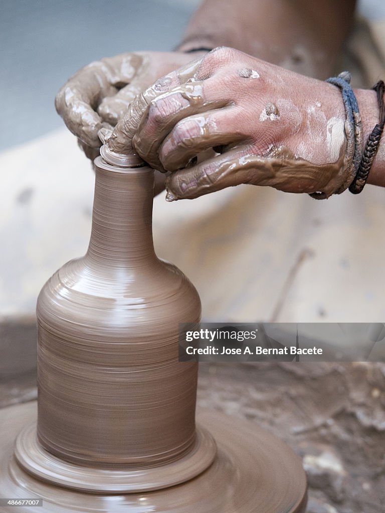 Potter shaping clay with a bottle