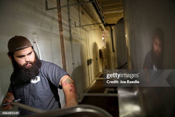 David Rodriguez, a beer brewer, uses a rake to pull the malted barley from the mash tun at Wynwood Brewing Company on April 25, 2014 in Miami,...