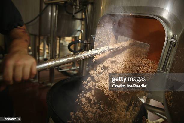 David Rodriguez, a beer brewer, uses a rake to pull the malted barley from the mash tun at Wynwood Brewing Company on April 25, 2014 in Miami,...