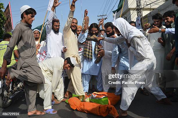 Supporters of Pakistan religious party, Muslim Students Organization , burning Indian flag and an effigy of Indian Prime Minister Narendra Modi, to...