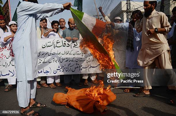 Supporters of Pakistan religious party, Muslim Students Organization , burning Indian flag and an effigy of Indian Prime Minister Narendra Modi, to...