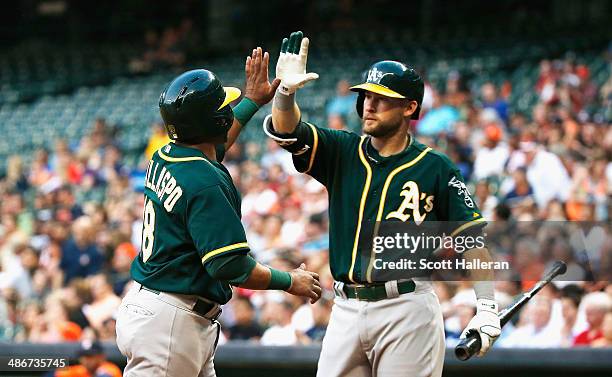 Alberto Callaspo and Daric Barton of the Oakland Athletics celebrate after Callaspo scored a run in the second inning of their game against the...