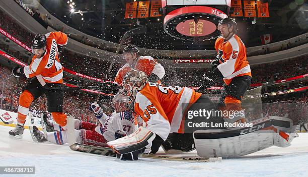 Andrew MacDonald, Matt Read, and Braydon Coburn of the Philadelphia Flyers defend Steve Mason while Ryan McDonagh of the New York Rangers falls into...