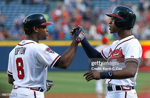 Justin Upton of the Atlanta Braves celebrates his three-run homer against the Cincinnati Reds in the first inning with B.J. Upton at Turner Field on...