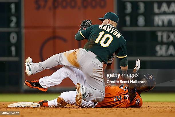 Daric Barton of the Oakland Athletics cannot make a play at second base on Dexter Fowler of the Houston Astros in the fourth inning during their game...