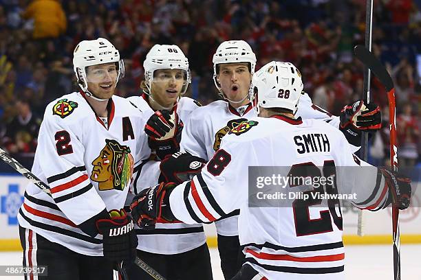 Duncan Keith, Patrick Kane and Sheldon Brookbank of the Chicago Blackhawks congratulate Ben Smith of the Chicago Blackhawks after Smith scored a goal...