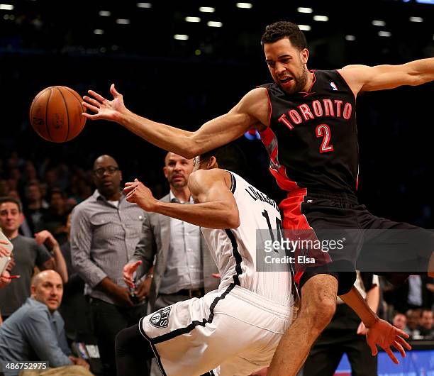 Landry Fields of the Toronto Raptors reaches for the loose ball over Shaun Livingston of the Brooklyn Nets in Game Three of the Eastern Conference...