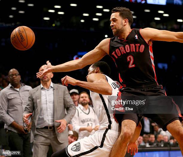 Landry Fields of the Toronto Raptors reaches for the loose ball over Shaun Livingston of the Brooklyn Nets in Game Three of the Eastern Conference...