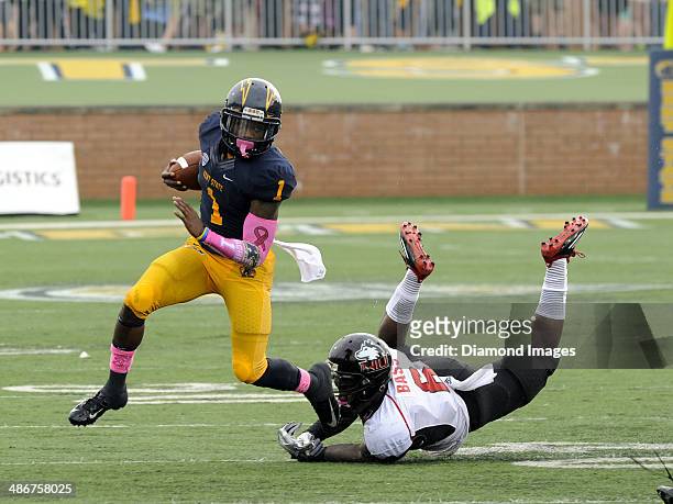 Wide receiver Dri Arher of the Kent State Golden Flashes escapes the tackle of defensive back Jamaal Bass of the Northern Illinois Huskies during a...