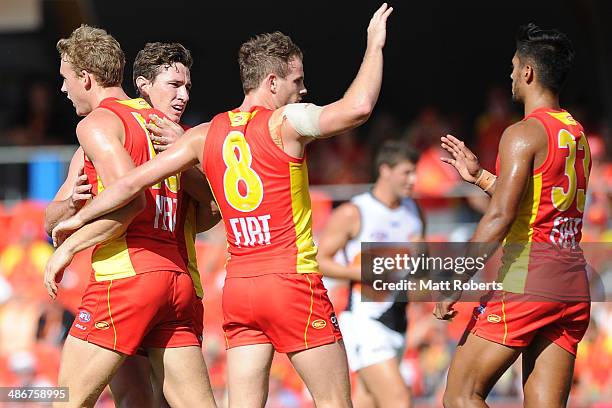 Tom Lynch of the Suns celebrates kicking a goal with team-mates during the round six AFL match between the Gold Coast Suns and the Greater Western...