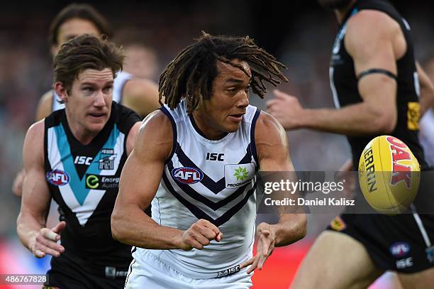 Tendai Mzungu of the Dockers handballs during the round 23 AFL match between the Port Adelaide Power and the Fremantle Dockers at Adelaide Oval on...