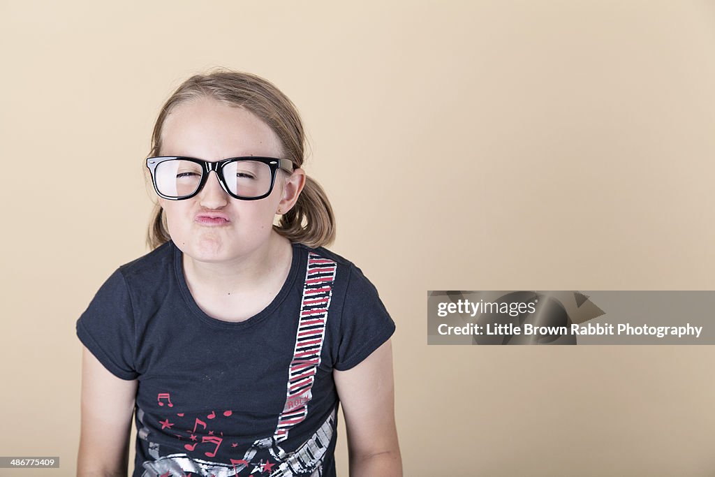 Girl Pulling a Silly Face in Black-Rimmed Glasses