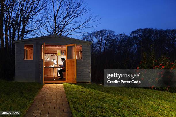 man working in garden shed at night - shed fotografías e imágenes de stock