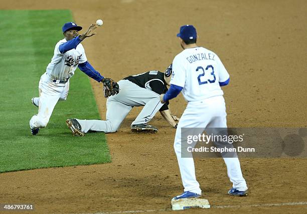 Second baseman Dee Gordon of the Los Angeles Dodgers flips the ball to first baseman Adrian Gonzalez to complete a double play after tagging out...