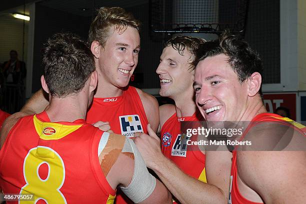 Tom Lynch of the Suns celebrates victory with team-mates Trent McKenzie and Danny Stanley after the round six AFL match between the Gold Coast Suns...