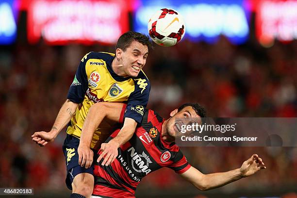 Storm Roux of the Mariners heads the ball over Mark Bridge of the Wanderers during the A-League Semi Final match between the Western Sydney Wanderers...