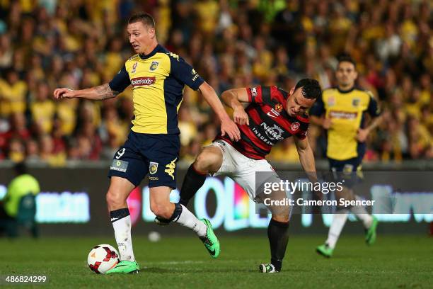 Mitchell Duke of the Mariners contests the ball with Mark Bridge of the Wanderers during the A-League Semi Final match between the Western Sydney...