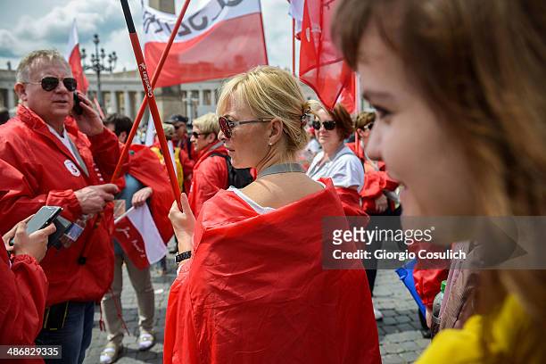 Polish pilgrims hold flags as they gather in Saint Peter's Square on April 26, 2014 in Vatican City, Vatican. Dignitaries, heads of state and Royals...