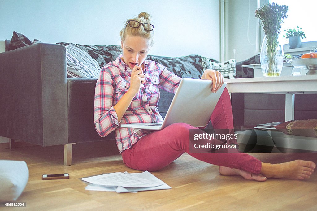 Young woman at home working on a laptop computer