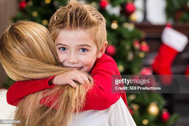 happy little boy hugging mom on christmas morning - kid stocking stock pictures, royalty-free photos & images