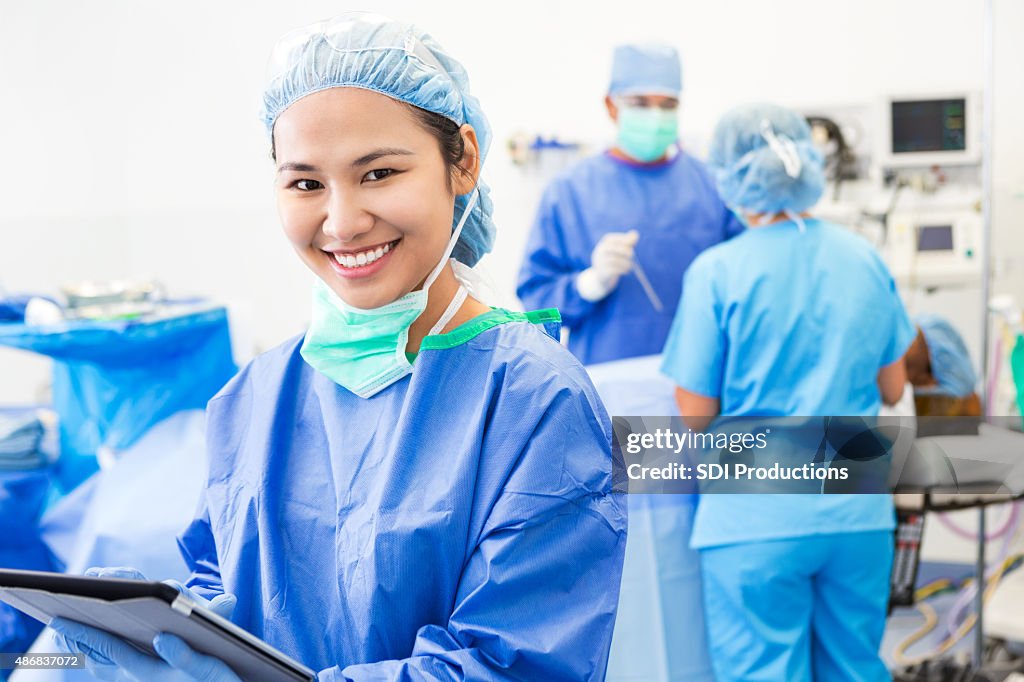 Asian surgeon or nurse using digital tablet in operating room