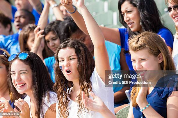 high school sports fans cheering for team in stadium - high school football stockfoto's en -beelden