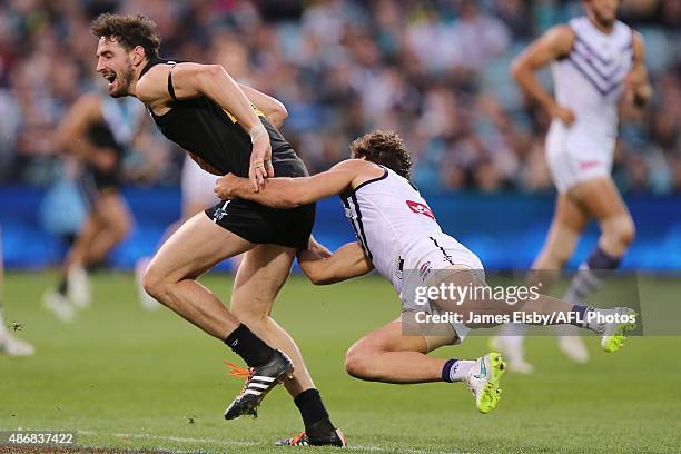 John Butcher of the Power is tackled by Matt de Boer of the Dockers during the 2015 AFL round 23 match between Port Adelaide Power and the Fremantle...