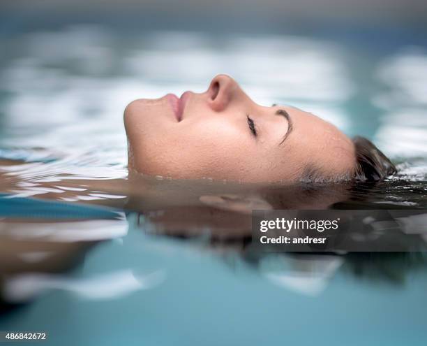 woman at the spa relaxing at the swimming pool - hydrotherapy stock pictures, royalty-free photos & images