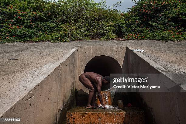 Homeless people bathes in sewage pipe that flows into the Tiete River, the largest and most polluted river on April 25, 2014 in Sao Paulo, Brazil....