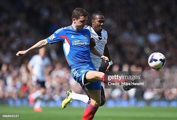 Alex Bruce of Hull clears ubder pressure from Hugo Rodallega of Fulham during the Barclays Premier League match between Fulham and Hull City at...