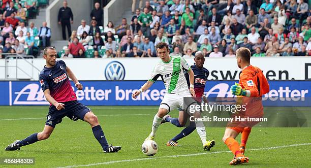 Ivan Perisic of Wolfsburg scores his team's second goal against goalkeeper Oliver Baumann of Freiburg during the Bundesliga match between VfL...