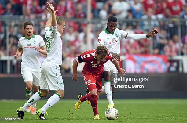 Mario Goetze of Muenchen is challenged by Felix Kroos and Eljero Elia of Bremen during the Bundesliga match between Bayern Muenchen and Werder Bremen...