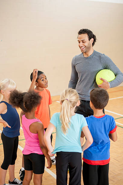kids listening to their gym coach - girls volleyball stock pictures, royalty-free photos & images