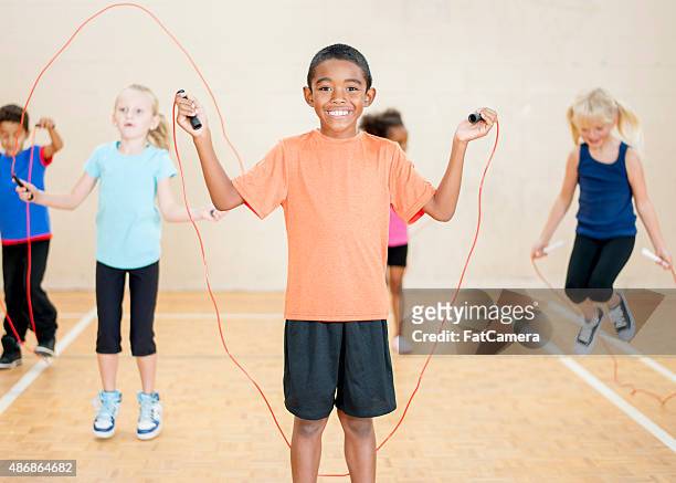 children jumping rope at school - spring training stockfoto's en -beelden