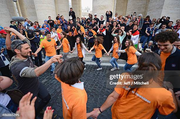 Pilgrims dance and pray as they wait to enter the Basilica in Saint Peter's Square on April 26, 2014 in Vatican City, Vatican. Dignitaries, heads of...