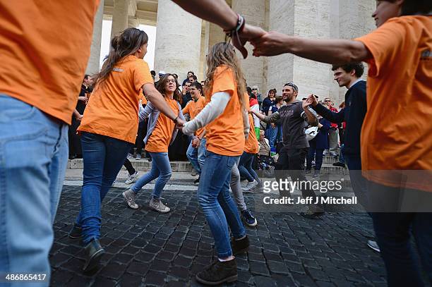 Pilgrims dance and pray as they wait to enter the Basilica in Saint Peter's Square on April 26, 2014 in Vatican City, Vatican. Dignitaries, heads of...