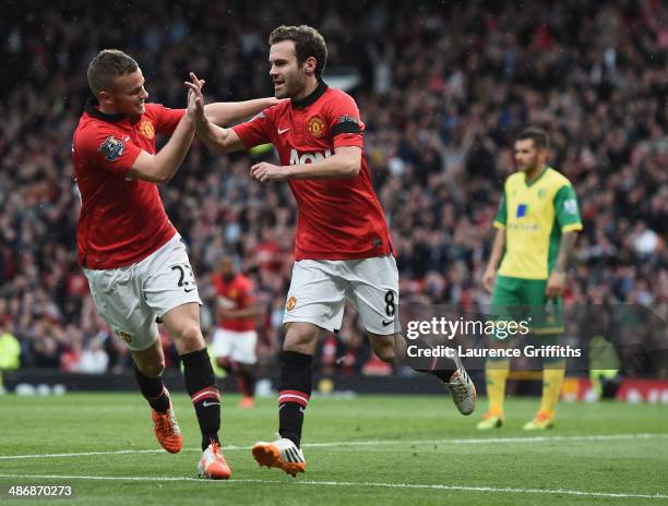 Juan Mata of Manchester United celebrates scoring the third goal with Tom Cleverley during the Barclays Premier League match between Manchester...