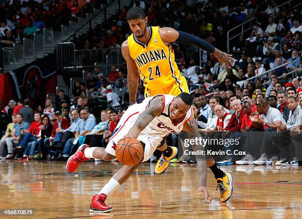 Jeff Teague of the Atlanta Hawks draws a foul from Paul George of the Indiana Pacers in Game Four of the Eastern Conference Quarterfinals during the...