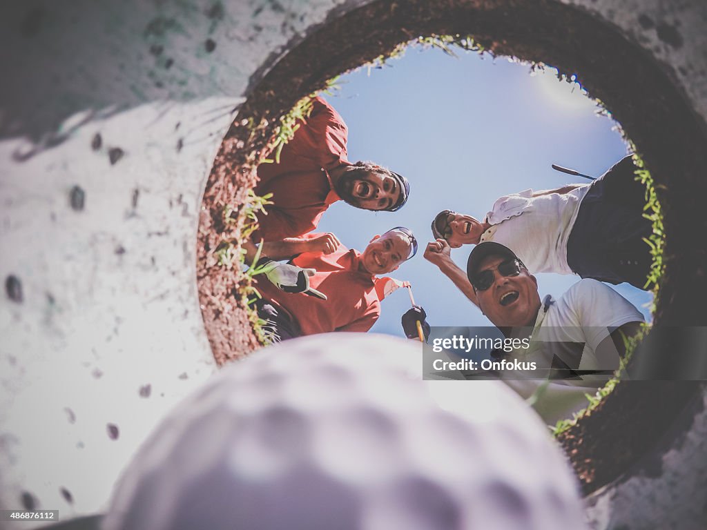 Point Of View Golf Players and Ball From Inside Hole