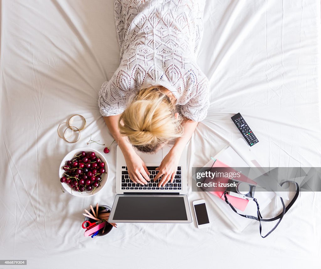 Woman using a laptop in the bed