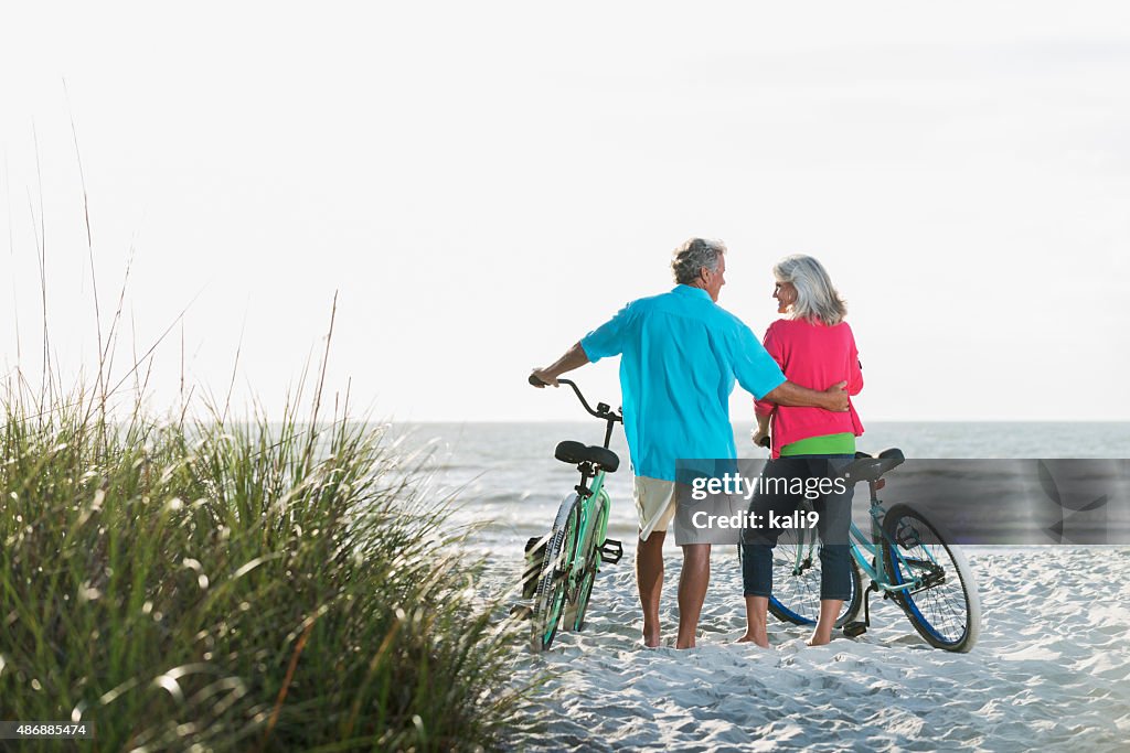 Mature couple with bicycles at the beach