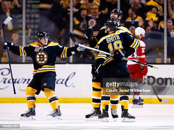 Zdeno Chara of the Boston Bruins celebrates his goal at the end of the second period with teammates Reilly Smith and Torey Krug against the Detroit...