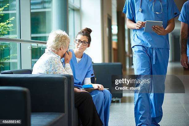 consoling a worried relative in the hospital - nurse huddle stock pictures, royalty-free photos & images