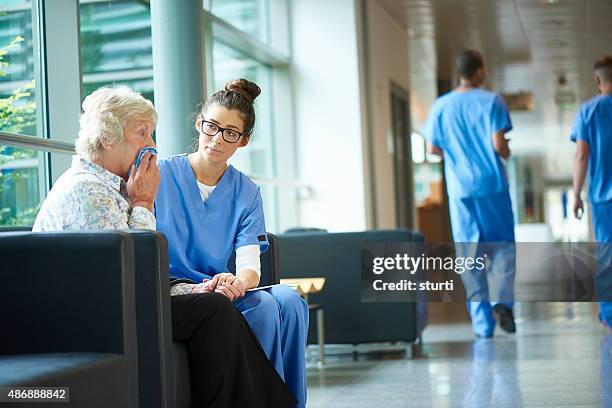 consoling a worried relative in the hospital - nurse huddle stock pictures, royalty-free photos & images