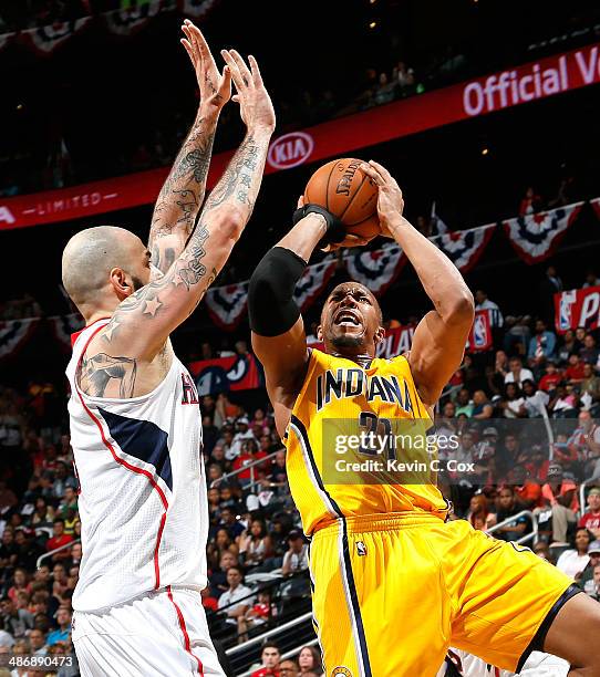 David West of the Indiana Pacers shoots against Pero Antic of the Atlanta Hawks in Game Four of the Eastern Conference Quarterfinals during the 2014...